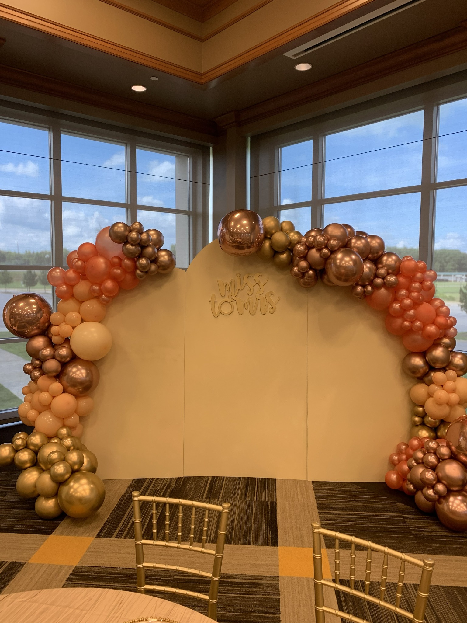 A peach bridal-shower backdrop reading Miss to Mrs framed with peach, bronze and gold balloons